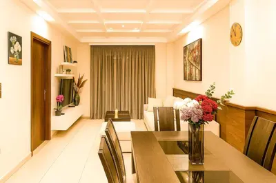 a dining room with a table with flowers in a vase at Oulang Cozy Apartment Athens- Acropolis View Haven in Athens