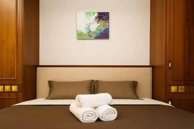 a bedroom with a bed with towels on it at Oulang Cozy Apartment Athens- Acropolis View Haven in Athens