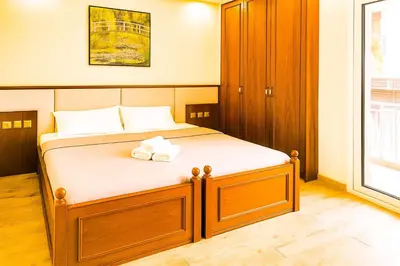 a bedroom with a large bed with a wooden headboard at Oulang Cozy Apartment Athens- Acropolis View Haven in Athens