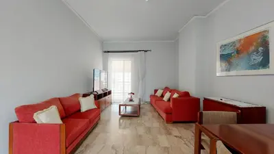 a living room with two red couches and a table at Modern, Renovated Apartment in Nikaia in Piraeus