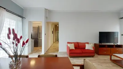 a living room with a red couch and a table at Modern, Renovated Apartment in Nikaia in Piraeus