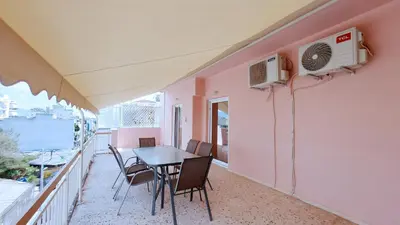 a balcony with a table and chairs and a heater at Modern, Renovated Apartment in Nikaia in Piraeus