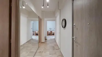 a hallway with white walls and a clock on the wall at Modern, Renovated Apartment in Nikaia in Piraeus