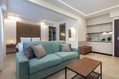 a living room with a blue couch and a bed at Ermou Kaliendia Suite in Athens