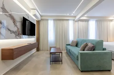 a living room with a couch and a tv at Ermou Kaliendia Suite in Athens