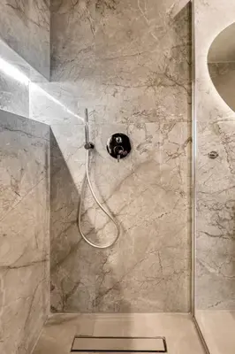 a shower with a hose in a bathroom at Ermou Kaliendia Suite in Athens
