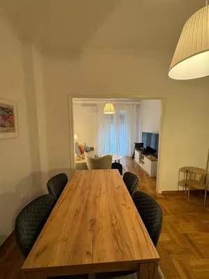 a living room with a wooden table and chairs at Cozy & Fully renovated apartment in Athens