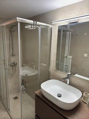 a bathroom with a sink and a glass shower at Cozy & Fully renovated apartment in Athens
