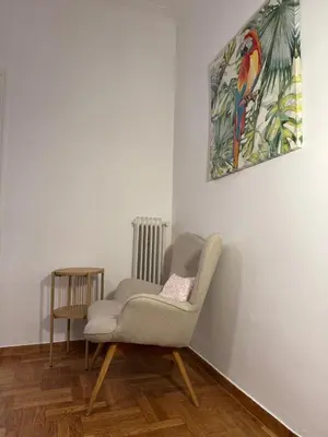 a chair in a room with a painting on the wall at Cozy & Fully renovated apartment in Athens