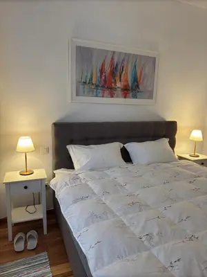 a bedroom with a large white bed with two lamps at Cozy & Fully renovated apartment in Athens
