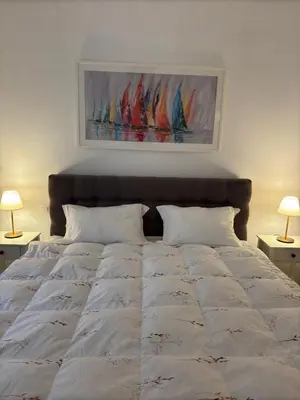 a bedroom with a large white bed with two lamps at Cozy & Fully renovated apartment in Athens