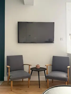 two chairs and a table with a tv on a wall at Syntagma Urban Residences in Athens