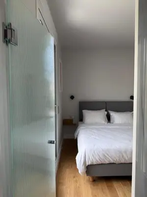 a bedroom with a bed and a glass door at Syntagma Urban Residences in Athens