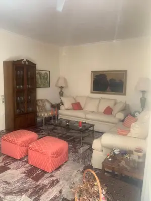 a living room with two white couches and red pillows at Παλαιό Φάληρο Αθηναϊκή Ριβιέρα in Athens