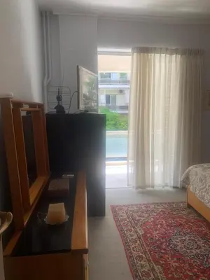 a living room with a bed and a large window at Παλαιό Φάληρο Αθηναϊκή Ριβιέρα in Athens