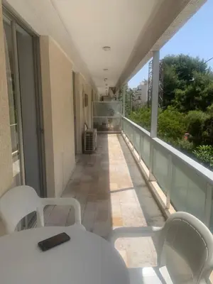 a balcony with a white table and chairs on a building at Παλαιό Φάληρο Αθηναϊκή Ριβιέρα in Athens