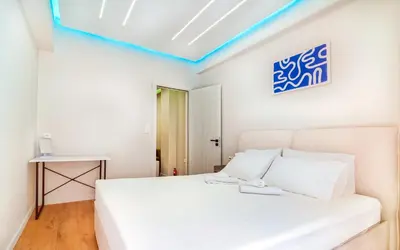 a white bedroom with a white bed and a blue light at Melina's Apartment Neo Psychiko in Athens
