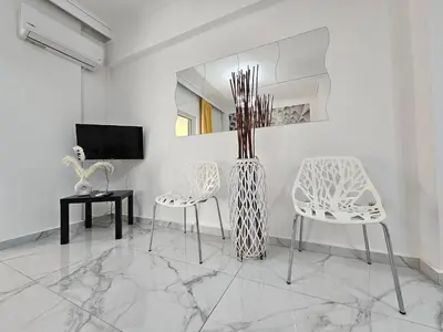 two chairs and a table in a room with a mirror at SantaRoza Luxury Apartment in Piraeus