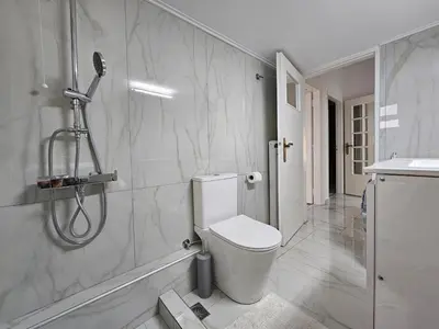 a white bathroom with a shower and a toilet at SantaRoza Luxury Apartment in Piraeus