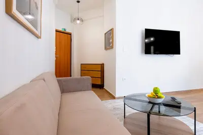 a living room with a couch and a glass table at Koukaki 2BR Apt with Balcony, Walk to Acropolis in Athens