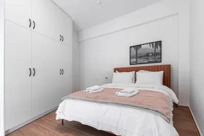 a bedroom with a bed with two towels on it at Koukaki 2BR Apt with Balcony, Walk to Acropolis in Athens