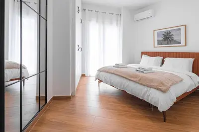 a bedroom with a large bed and a wooden floor at Koukaki 2BR Apt with Balcony, Walk to Acropolis in Athens