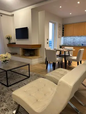a living room with a couch and a table at Altitude 5 Penthouse Elliniko in Athens