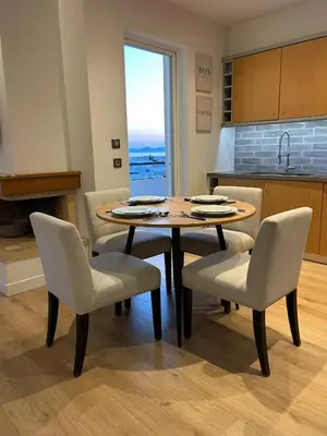 a table and chairs in a kitchen with a table at Altitude 5 Penthouse Elliniko in Athens