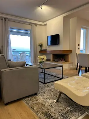 a living room with a couch and a table at Altitude 5 Penthouse Elliniko in Athens