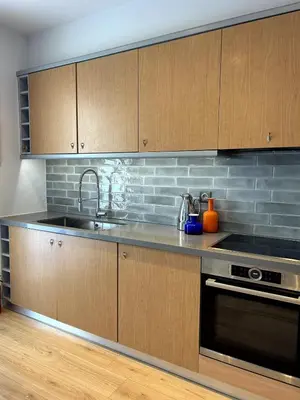 a kitchen with wooden cabinets and a sink at Altitude 5 Penthouse Elliniko in Athens