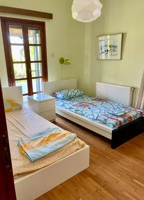 a bedroom with two beds and a window at Lagonisi2025 in Kalívia Thorikoú