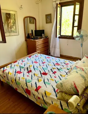 a bed with a colorful comforter in a bedroom at Lagonisi2025 in Kalívia Thorikoú