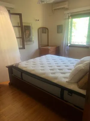 a large bed in a bedroom with a window at Lagonisi2025 in Kalívia Thorikoú