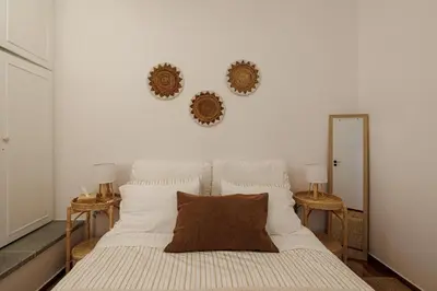 a bedroom with a large white bed with two mirrors at Sunlit homie flat at Arrianou! in Athens