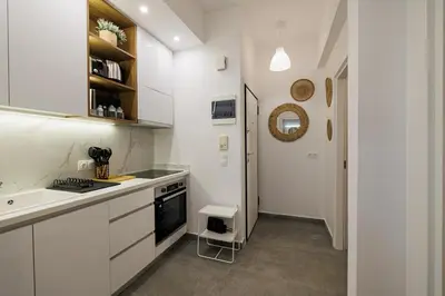 a white kitchen with a sink and a stove at Sunlit homie flat at Arrianou! in Athens