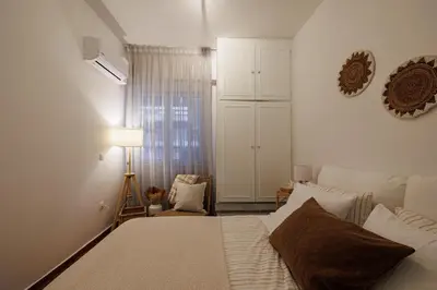 a bedroom with a bed and a lamp and a window at Sunlit homie flat at Arrianou! in Athens