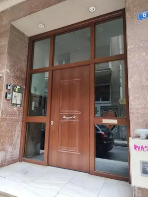 a wooden door on a building with glass windows at Cozy and totally sunny apartment in Athens