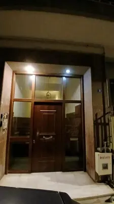 a large wooden door in a building with a light at Cozy and totally sunny apartment in Athens