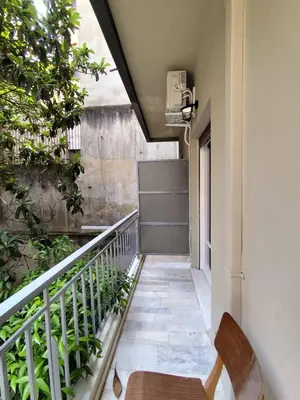 a hallway with two chairs and a balcony with plants at Cozy and totally sunny apartment in Athens