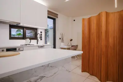a kitchen with a white counter and a wooden door at Lime house in Athens