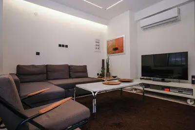 a living room with a couch and a flat screen tv at Lime house in Athens