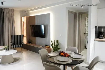 a living room with a table and chairs and a kitchen at Airrent Apartments 2 Designer Stay Free Parking Quiet Central in Athens