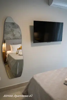 a bedroom with a mirror and a bed and a tv at Airrent Apartments 2 Designer Stay Free Parking Quiet Central in Athens