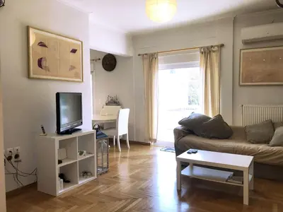 a living room with a couch and a tv at Quiet, central, on airport metro and bus line in Athens