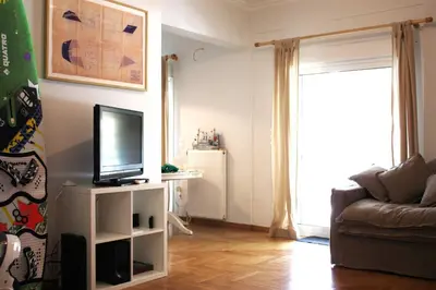 a living room with a television and a couch at Quiet, central, on airport metro and bus line in Athens