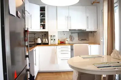 a kitchen with white cabinets and a white table at Quiet, central, on airport metro and bus line in Athens