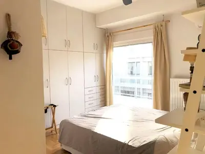 a bedroom with a bed and a large window at Quiet, central, on airport metro and bus line in Athens