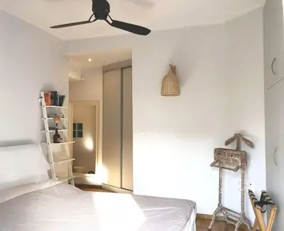 a bedroom with a bed and a ceiling fan at Quiet, central, on airport metro and bus line in Athens