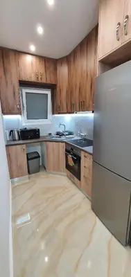 a kitchen with wooden cabinets and a white refrigerator at Near the Pasha Limani in Piraeus