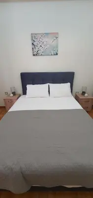 a bedroom with a large white bed with two night stands at Near the Pasha Limani in Piraeus